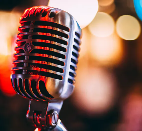 A close-up of a vintage microphone surrounded by soft glowing lights, inviting visitors to listen.