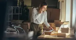A woman on a cell phone in a warehouse.