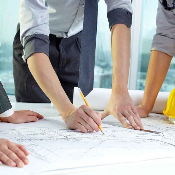 Team collaborating on architectural blueprints.
